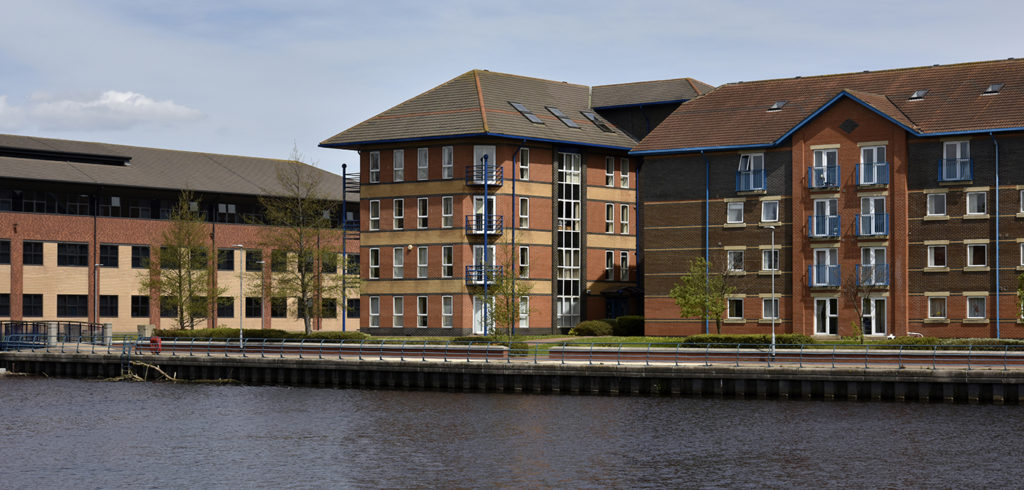 Co*Shabang Offices Stockton on Tees for co-working, co-sharing, hot desking, office & meeting room rentals.  Outside view from across the river of modern red brick building